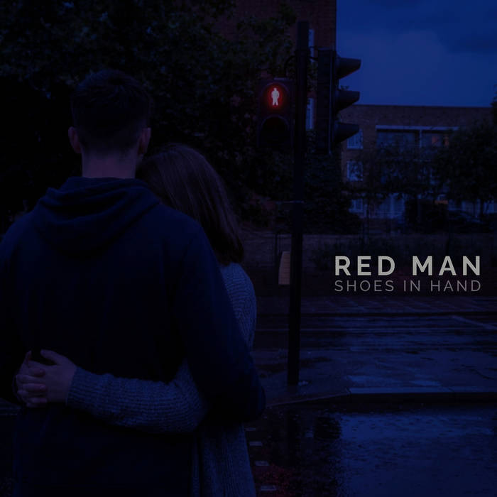 Red Man cover: A couple at a crossing at night, the red pedestrian light lit